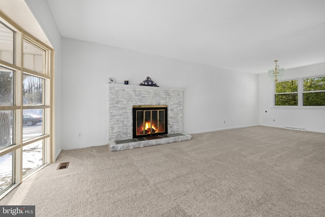 unfurnished living room with carpet flooring and a fireplace