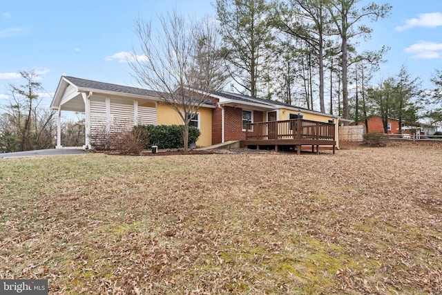 back of property featuring a deck, a yard, brick siding, and fence