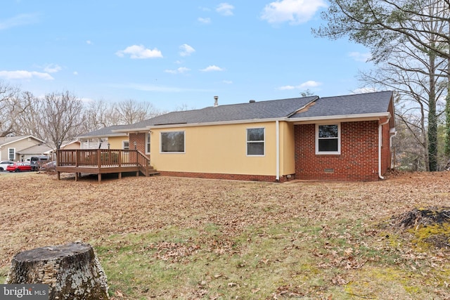 rear view of house with a deck, brick siding, crawl space, and a shingled roof