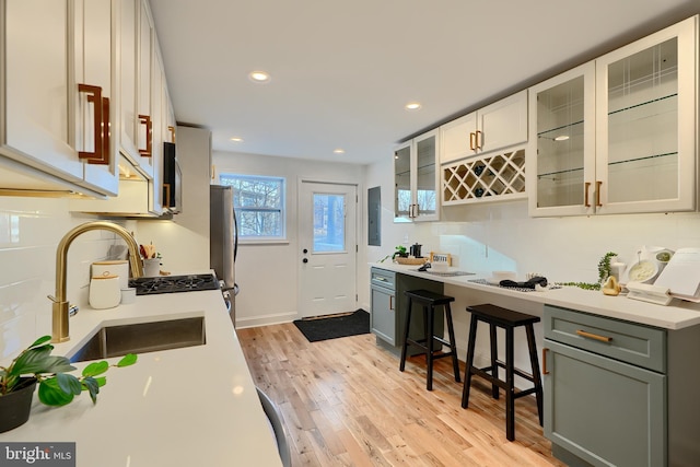 kitchen featuring stainless steel fridge, gray cabinetry, white cabinetry, electric panel, and light hardwood / wood-style floors