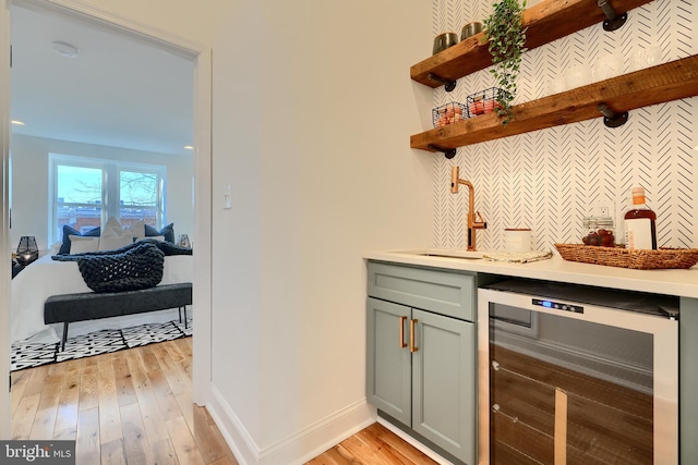 kitchen featuring sink, wine cooler, and light wood-type flooring