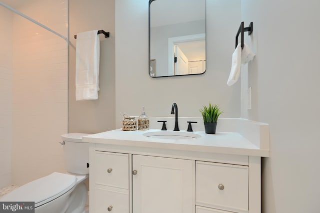 bathroom featuring walk in shower, vanity, and toilet