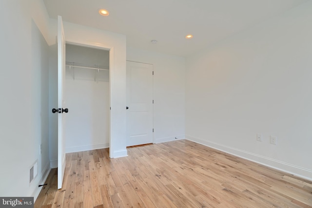 unfurnished bedroom featuring a closet and light wood-type flooring