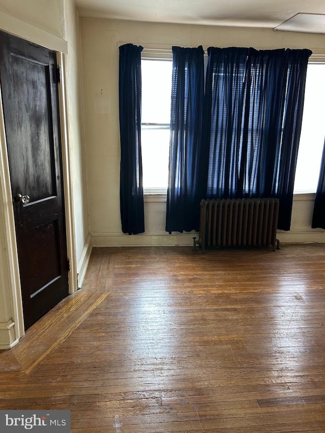 foyer with radiator heating unit and hardwood / wood-style floors