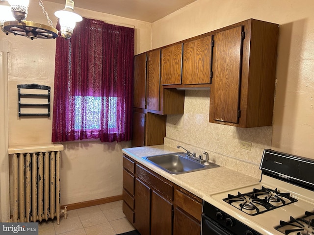 kitchen featuring sink, a chandelier, range with gas stovetop, and radiator