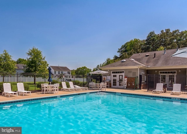 view of swimming pool with french doors