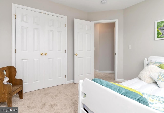 bedroom with light colored carpet and a closet