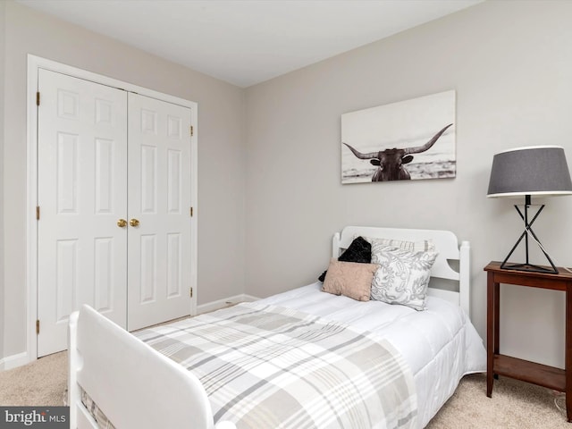 bedroom featuring light colored carpet and a closet