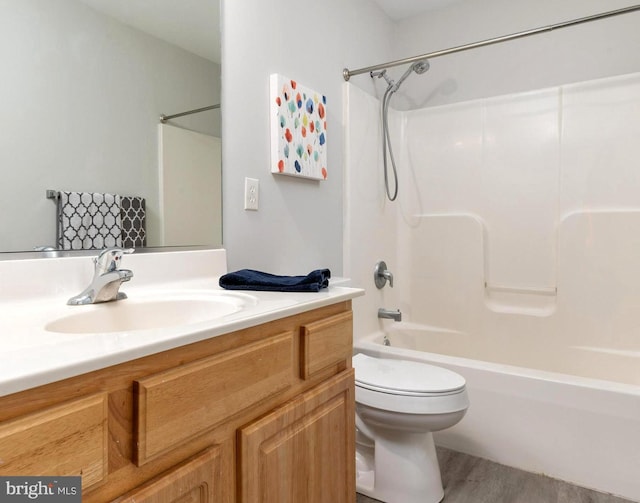 full bathroom featuring hardwood / wood-style flooring, vanity, bathtub / shower combination, and toilet