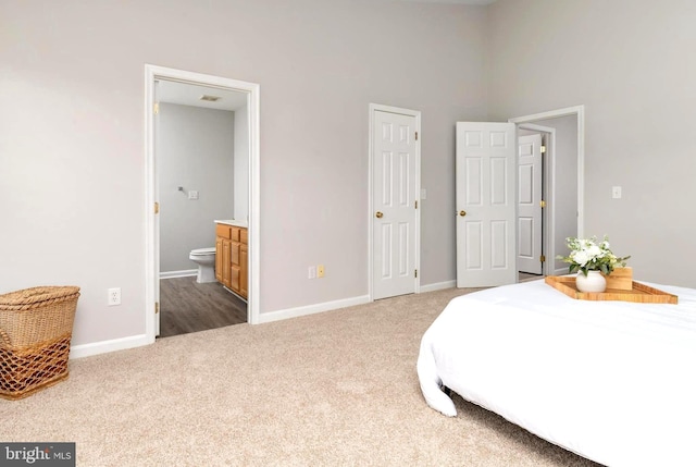 bedroom featuring connected bathroom and carpet flooring