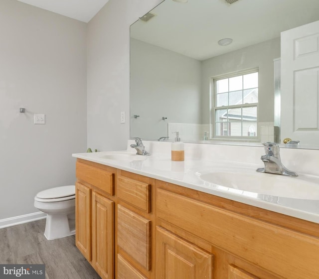 bathroom with wood-type flooring, vanity, and toilet