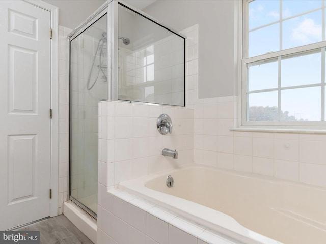 bathroom featuring wood-type flooring and separate shower and tub