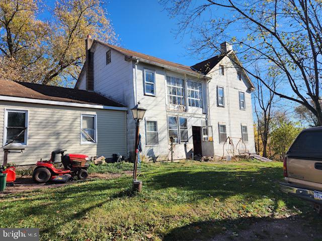 back of house with a lawn