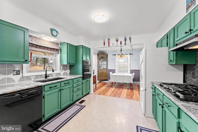 kitchen with sink, light stone counters, black appliances, and green cabinetry