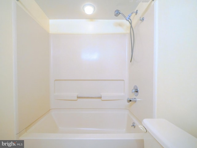 bathroom featuring shower / washtub combination and toilet