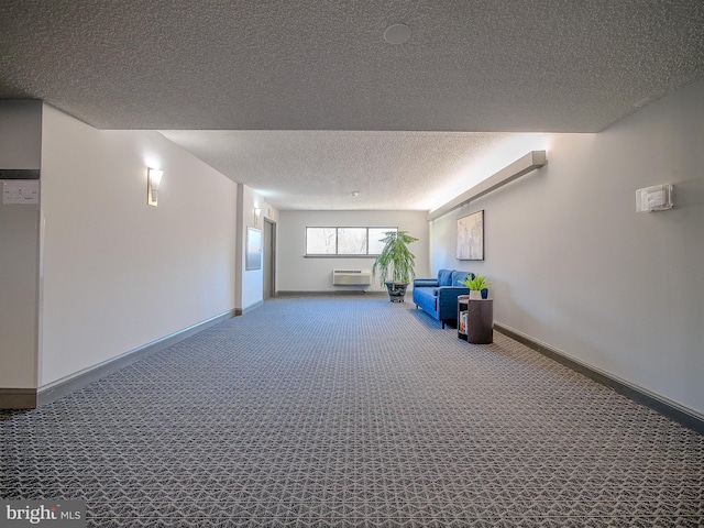 hall featuring a wall unit AC, carpet, and a textured ceiling