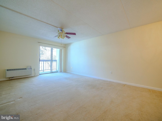 carpeted empty room featuring ceiling fan, a wall mounted AC, and a textured ceiling