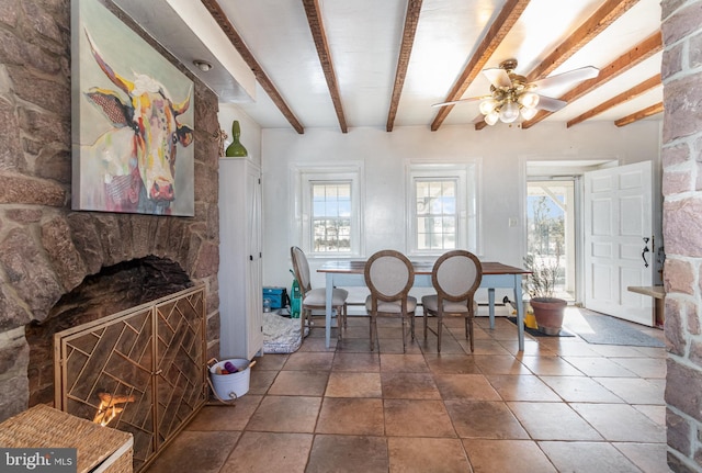 dining area with beam ceiling, ceiling fan, and a fireplace