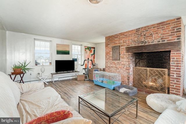 living room with hardwood / wood-style flooring and a brick fireplace