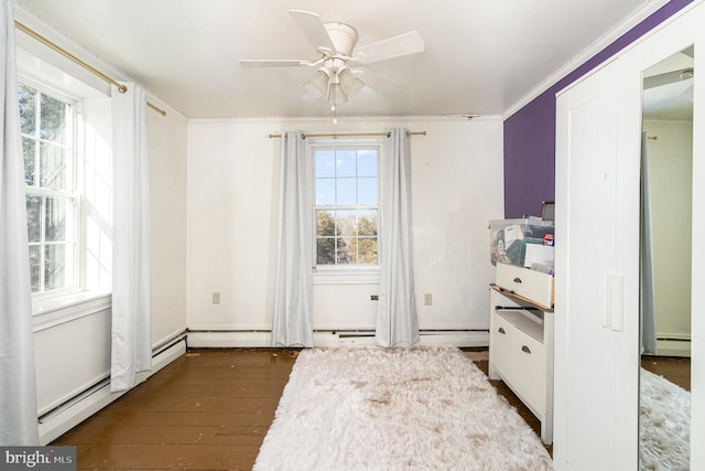 interior space with a baseboard heating unit, crown molding, dark wood-type flooring, and ceiling fan