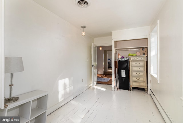 bedroom with ornamental molding and a baseboard heating unit