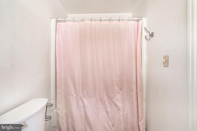 bathroom featuring toilet and walk in shower