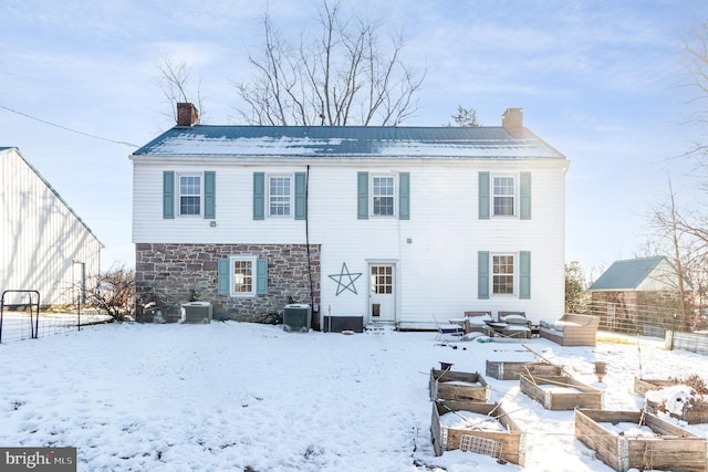 snow covered house featuring central AC