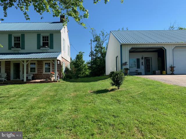 view of home's exterior featuring a garage, a yard, and covered porch