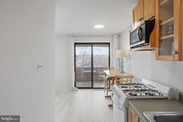 kitchen with white range with gas stovetop and light hardwood / wood-style flooring