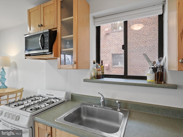 kitchen featuring white range with gas cooktop and sink