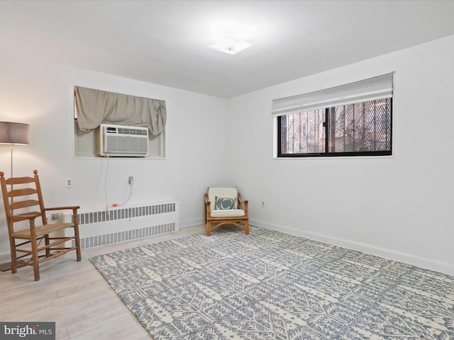 sitting room with light hardwood / wood-style flooring, radiator heating unit, and cooling unit