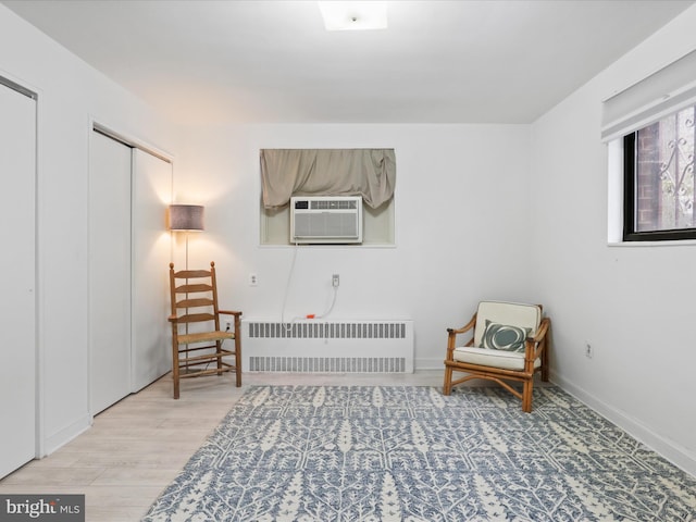 sitting room with radiator heating unit and light wood-type flooring