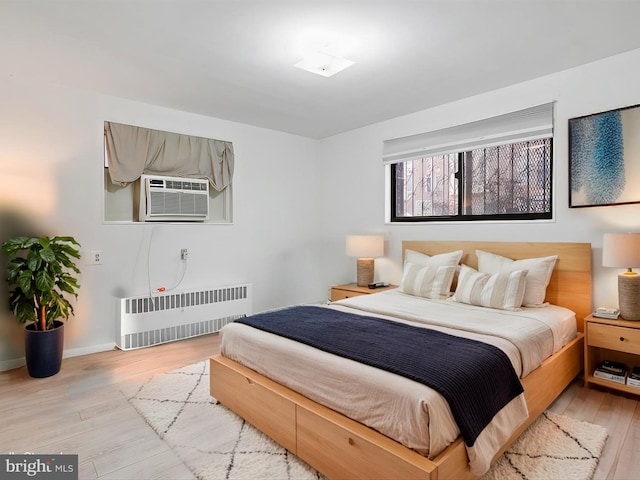 bedroom featuring cooling unit, radiator, and light hardwood / wood-style floors