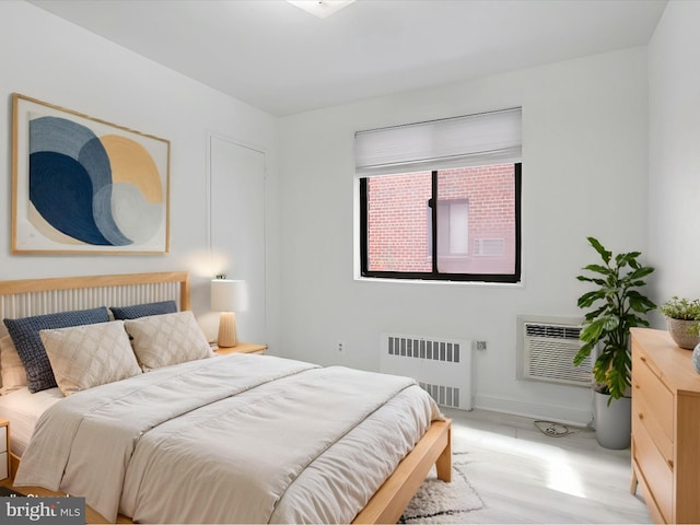 bedroom with radiator and a wall unit AC