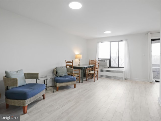 sitting room featuring cooling unit, radiator, and light hardwood / wood-style floors