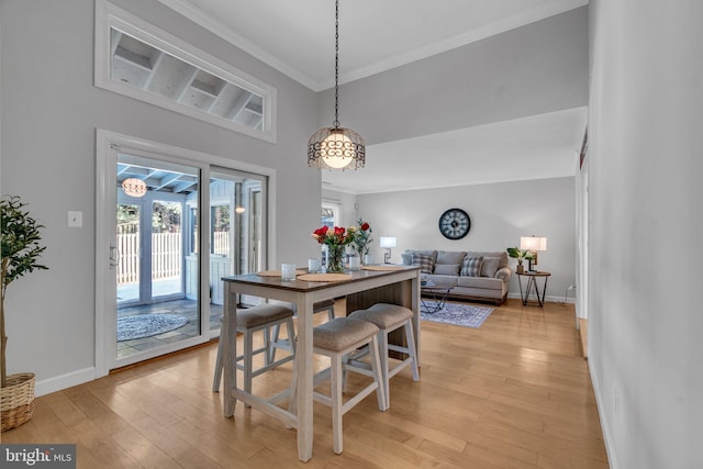 dining room with crown molding, french doors, and light wood-type flooring