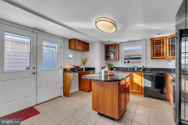 kitchen with sink, light tile patterned floors, a center island, black dishwasher, and a healthy amount of sunlight