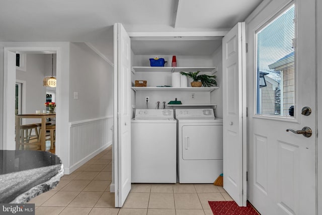 clothes washing area featuring washer and dryer and light tile patterned floors