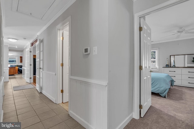 corridor featuring crown molding and light tile patterned flooring