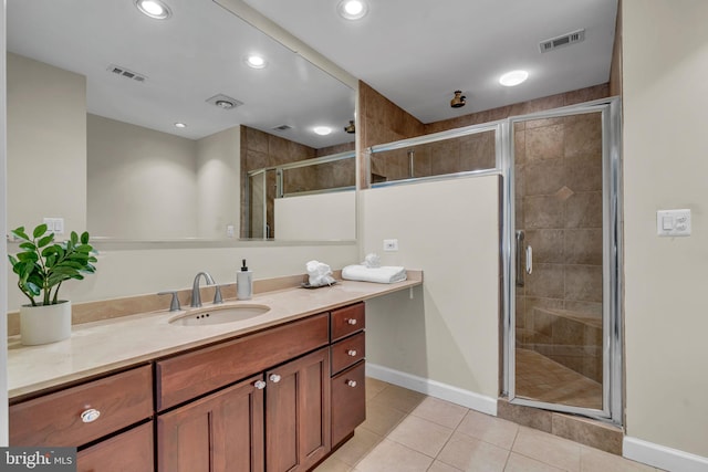 bathroom featuring a shower with door, vanity, and tile patterned floors