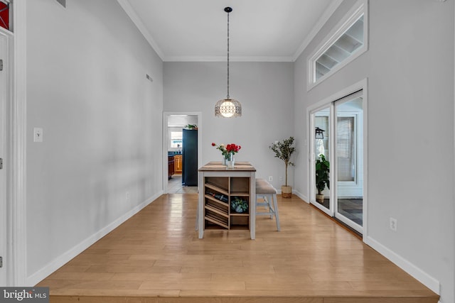 dining room featuring ornamental molding and light wood-type flooring