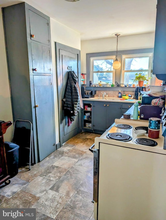 kitchen featuring hanging light fixtures, sink, and white range with electric cooktop