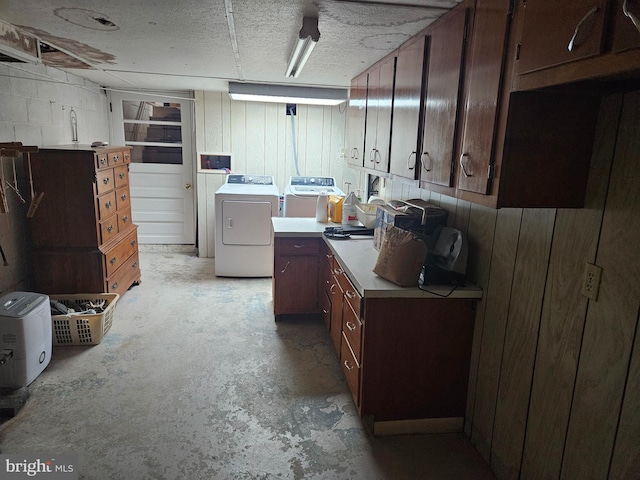 washroom with cabinets, washer and dryer, and a textured ceiling