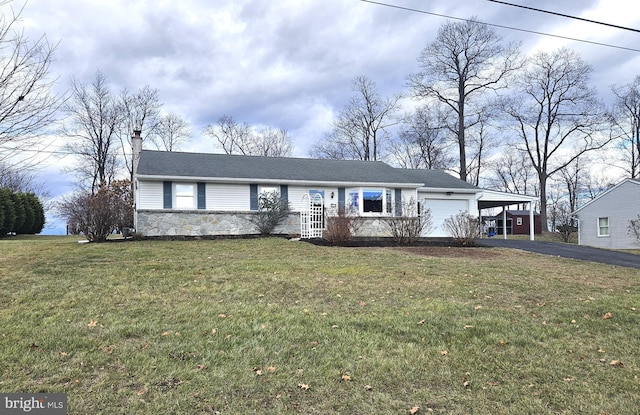 ranch-style house with a garage, a front yard, and a carport