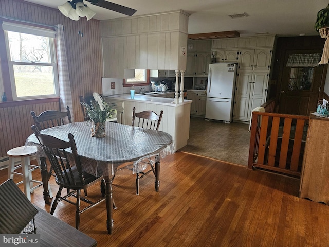 dining space with dark hardwood / wood-style flooring and ceiling fan