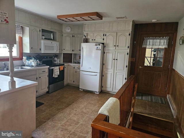 kitchen featuring white cabinetry, sink, white appliances, and a baseboard radiator