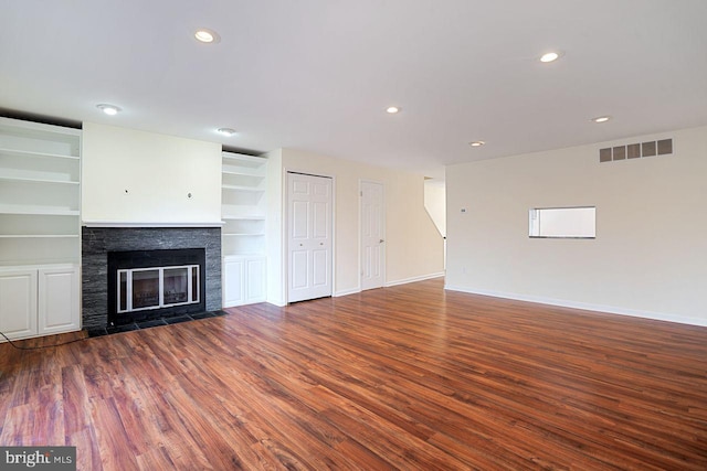 unfurnished living room featuring dark wood-type flooring and built in features