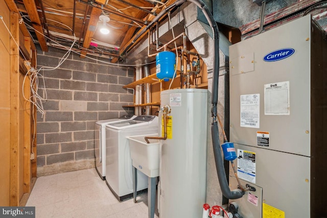 utilities featuring gas water heater, sink, heating unit, and washer and clothes dryer