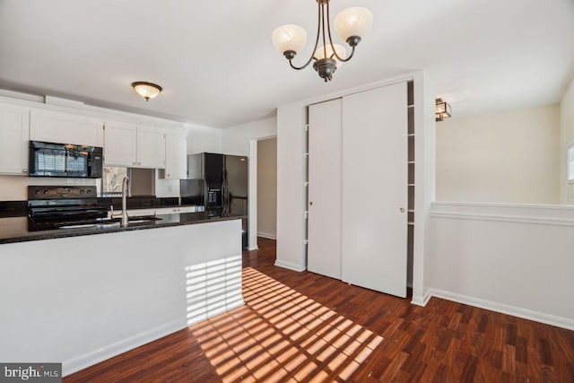 kitchen with white cabinetry, an inviting chandelier, dark hardwood / wood-style floors, pendant lighting, and black appliances