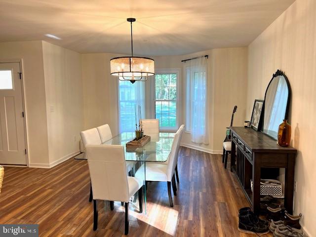 dining space with an inviting chandelier and dark hardwood / wood-style floors